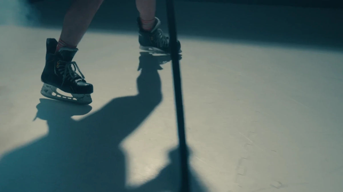 Close-up of hockey skates and a stick on ArcticGlide Pro panels